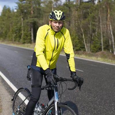 Heikki Mäkelä pyörän kanssa maantiellä.