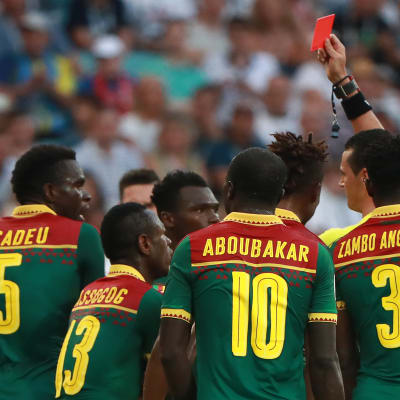 Erotuomari Wilmar Roldán nostaa punaisen kortin Kamerunin pelaajalle.