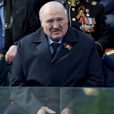 Valko-Venäjän presidentti Aljaksandr Lukashenka istuu katsomassa Voitonpäivän paraatia Moskovassa, taustalla näkyy univormuja.