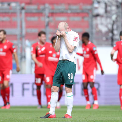 Werder Bremen menetti mahdollisuutensa suoraan säilyjän paikkaan Bundesliigassa. Mainz tuulettaa taustalla. Bremenin Davy Klaassen on kätkenyt kasvonsa pelipaitaan.