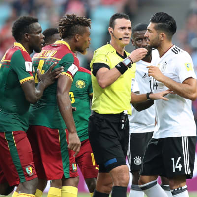 Domaren omringad av spelare i Confederations Cup