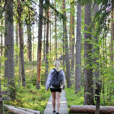 En kvinna går i en skog.