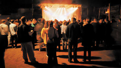 After Eightin Plutofestivaali vuonna 1998, ihmiset kuuntelevat Kemopetrol-yhtyettä sisäpihalle rakennetun lavan äärellä.