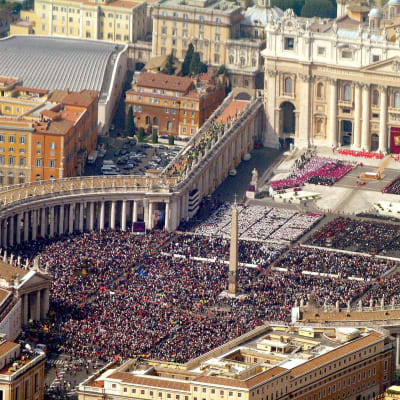 En flygbild visar att det är fullt av folk på Petersplatsen under påve Johannes Paulus II:s begravning år 2005. Även Peterskyrkans facad och en del av Vatikanstaten är med på bilden.