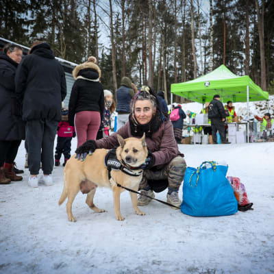 Desireé Saadaoui var på plats för att få mat åt sin hund Rosie: En kvinna sitter på huk och klappar en hund. Bredvid dem står en stor blå kasse.