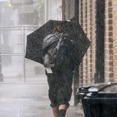 En kvinna promenerar på en gata i New Orleans, Louisiana som drabbas av orkanen Ida.