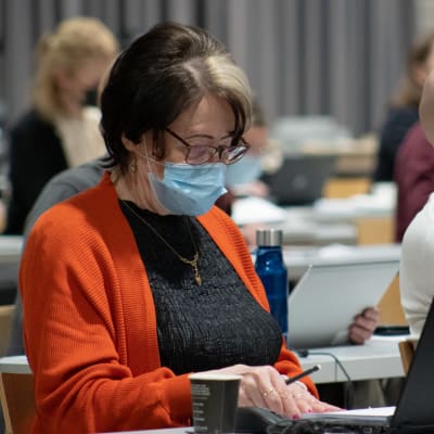 Päijät-Hämeen aluehallituksen 2.varapuheenjohtaja, SDP:n Anneli Viinikka lukee maski naamalla papereita kokouksessa. 