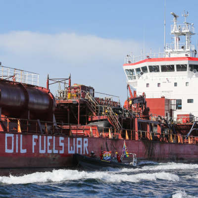 Oljetanker ute till havs där Greenpeace har skrivit Oil fuels war 