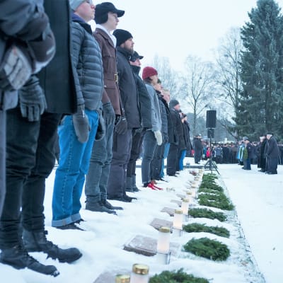 Miehiä sankariahutojen edessä talvella Suomen itsenäisyyspäivänä 2017.