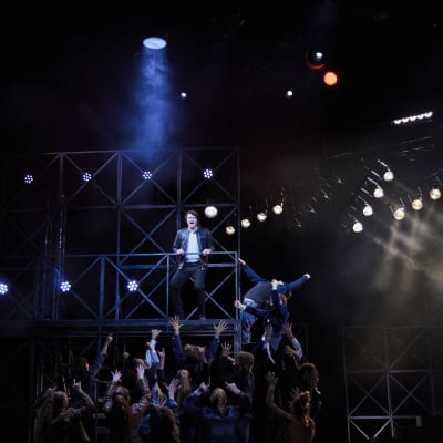 Rovaniemen teatterin Kirka esityksen promokuvassa Kirka seisoo telineillä ja yleisö (näyttelijät) yrittävät kiivetä hänen luokseen.