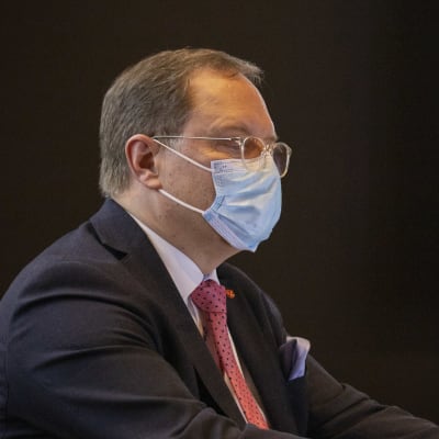 Ilkka Pirskanen istuu maski kasvoilla kokouspöydän takana.