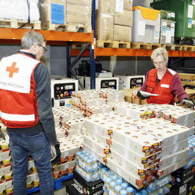 Punaisen Ristin työntekijät ja vapaaehtoiset lajittelivat ja pakkasivat avustuspakkauksia.