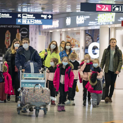 Resenärer i munskydd går på Helsingfors-Vanda flygplats.