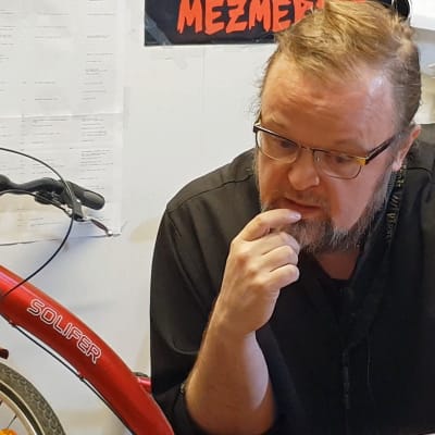 Professori ja pappismunkki Serafim Seppälä työhuoneessaan Joensuussa polkupyöränsä kanssa.