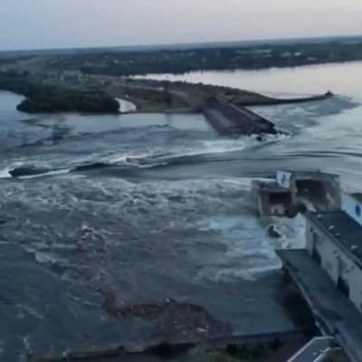 Vatten forsar igenom den spränga dammen i Nova Kachovka