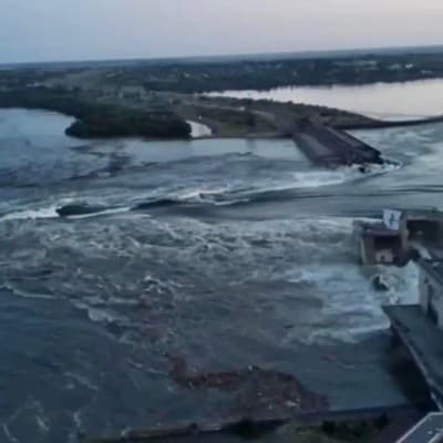 Vatten forsar igenom den spränga dammen i Nova Kachovka