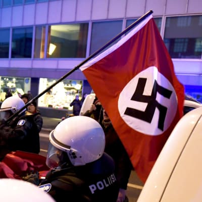 Nordiska motståndsrörelsen bär den nazistiska hakkorsflaggan under demonstration på självständighetsdagen 2018. Polisen griper in.