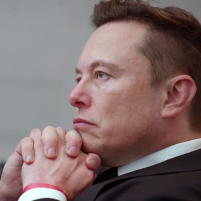 Elon Musk nojaa leukaansa käsiinsä.