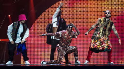 Fyra personer klädda i kläder inspirerade av den ukrainska folkdräkten står på en scen och uppträder.