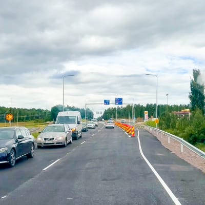En nyasfalterad riksväg 25 i Karis där bilar nu kan köra över en ny bro.