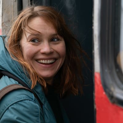 En leende Seidi Haarla på väg att stiga ombord på ett tåg. 