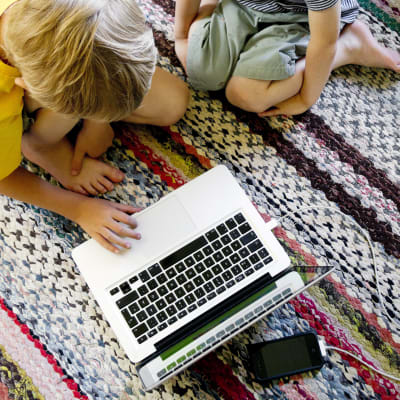 Kaksi pientä poikaa kannettavan tietokoneen äärellä.