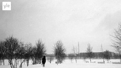 En man går på en stig i snön