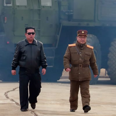 Pohjois-Korean johtaja Kim Jong-un kävelemässä. Taustalla iso ohjus.