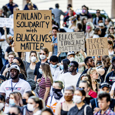 Ett hav av demonstranter med olika skyltar.