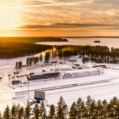 ilmakuva Kontiolahden ampumahiihtostadionista. Rakennuksia, luminta, jäätynyt Höytiäinen. 