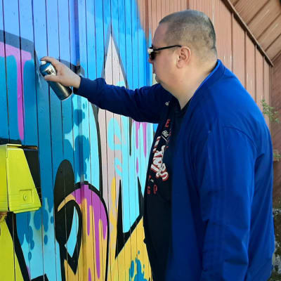 Jani Varismäki maalaa graffitia entisen Wasalandia-huvipuiston alueella Vaasassa.