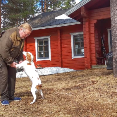 Lasse Linkoneva ja Fluffy koira mökillään Kuusamossa.