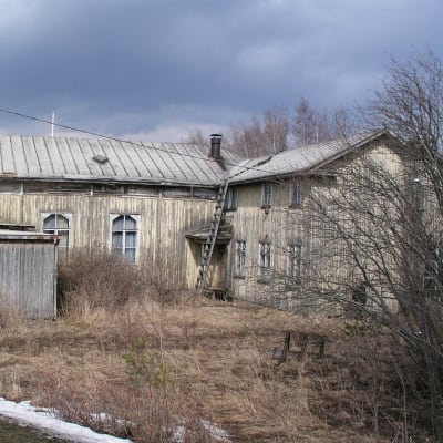 Ränsistynyt puutalo, jonka maalipinta on pahoin kulunut.  Piha on kasvanut myös umpeen ruohokasveja. 