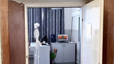 Dörren till klassrummet i en skola i Budapest står öppen och på lärarens plats ser vi ett skelett