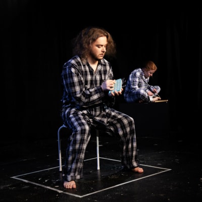 Mental Expo -näytelmän kaksi esiintyjää pyjamassa lavalla
