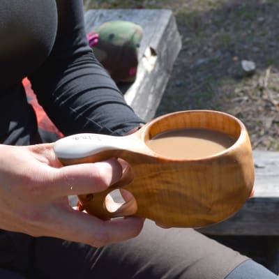 Närbild på en kåsa fylld med kaffe.