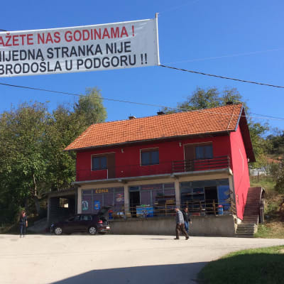 By i Bosnien med skylt över att politiker är förbjudna i byn. 