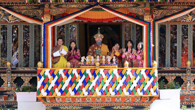 Bhutanin kuningas Wangchuck ja kuningatar Jetsun Pema katsovat kansallispäivän juhlallisuuksia koristeelliselta parvekkeelta.
