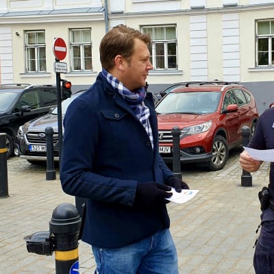 En svensk liberalkonservativ person ger åt en poliskonstapel ett flygblad där det står att estniska homosexuella är välkomna i Sverige.