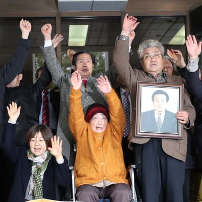 Kim Sung-joo ihmisjoukon keskellä. Kaikilla on kädet ilmassa.