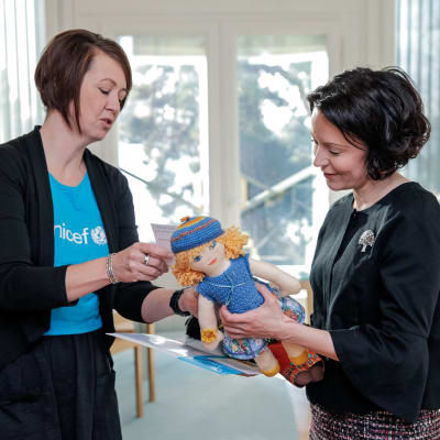 Presidentfrun Jenni Haukio tar emot en  Unicefdocka av Yvonne Korenius, ordförande för den frivilliga UNICEF-gruppen i Raseborg.