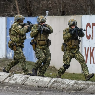 Soldater går med vapen under en militärövning i Ukraina.
