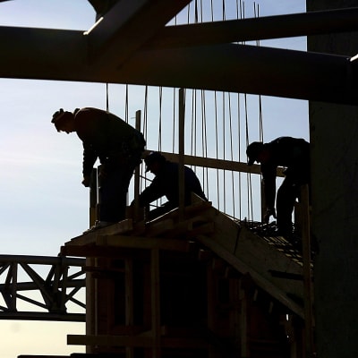 Tre arbetare vid ett bygge