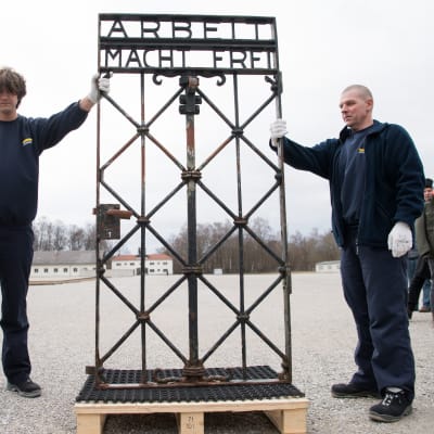 Dachaun keskitysleirin rautaportti varastettiin vuonna 2014. Norjasta joulukuussa löytynyt portti on saatu takaisin museoalueena toimivalle keskitysleirille. Kuvassa kaksi miestä esittelee rautaporttia, jossa lukee Arbeit macht frei.