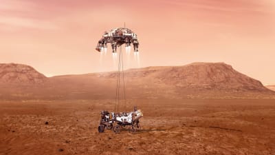 Perseverance sänker sig ned till Mars yta hängande från kablar.
