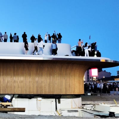 Folk har klättrat upp på paviljongen på Salutorget i Åbo. 