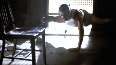 Demi Moore i filmen G.I. Jane från 1997. Hennes flintskalliga rollkaraktär gör armhävningar med en arm. 