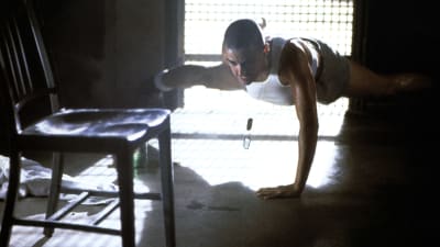 Jordan O'Neill (Demi Moore) tränar armhävningar på golvet med en arm.