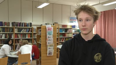 Profilbild på Joar Bergholm, flera ungdomar sitter i bakgrunden av bilden.