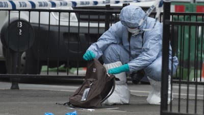 En utredare iklädd skyddsdräkt över hela kroppen undersöker en ryggsäck, efter gripandet av en terrormisstänkt i London.